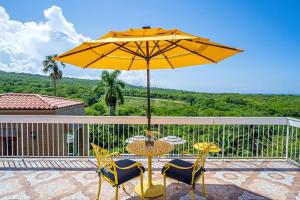 einen Tisch und Stühle mit Sonnenschirm auf einer Terrasse in der Unterkunft Private Tiny House w/ Pool in Montego Bay