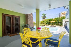einen gelben Tisch und Stühle auf einer Terrasse in der Unterkunft Private Tiny House w/ Pool in Montego Bay