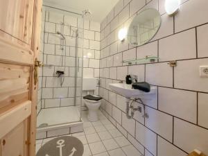 ein Badezimmer mit einem Waschbecken, einem WC und einem Spiegel in der Unterkunft Ferienwohnung Blick Neukoog in Nordstrand