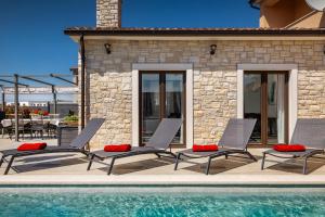 a group of chairs sitting next to a swimming pool at VILLA ISTRA in Kaštelir