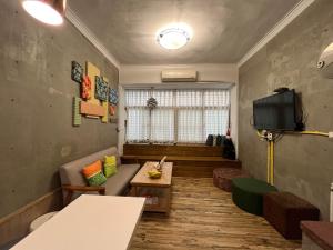 台南市にあるYou Ai Heya Homestayのソファとテレビのあるリビングルーム