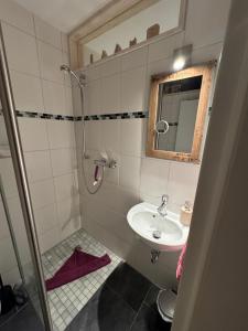 a small bathroom with a sink and a mirror at Cozy home- Altstadtferienwohnung Stade in Stade