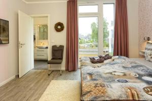 a bedroom with a bed and a bathroom with a window at Kapitaensweg 2 Kajuete 06 in Ostseebad Karlshagen