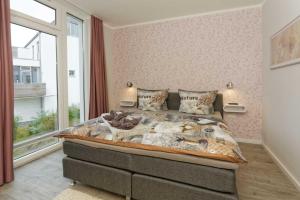 a bedroom with a large bed and a window at Kapitaensweg 2 Kajuete 06 in Ostseebad Karlshagen