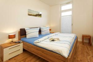a bedroom with a large bed with blue sheets at Kapitaensweg 4 Koje 01 in Ostseebad Karlshagen