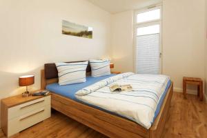 オストゼーバート・カールスハーゲンにあるKapitaensweg 4 Koje 01のベッドルーム1室(大型ベッド1台、青いシーツ付)