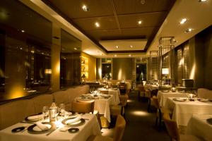 a restaurant with tables and chairs with white table settings at Villa Oniria in Granada