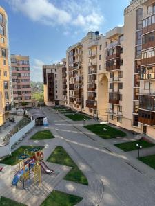 eine leere Straße mit Spielplatz vor den Gebäuden in der Unterkunft Затишні апартаменти TWO in Czernowitz