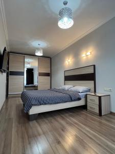 Schlafzimmer mit einem Bett, einer Kommode und einem Spiegel in der Unterkunft Затишні апартаменти TWO in Czernowitz