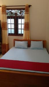 a large bed in a room with a window at Serene villa in Galle