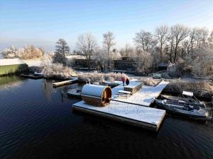 a group of boats are docked in the water at Pean-buiten Waterlodges in Nes