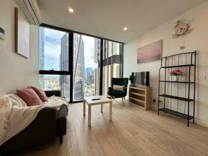 een woonkamer met een bank en een stoel en een groot raam bij Avant CBD Cozy & Spacious 2BR Residences in Melbourne
