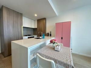 a kitchen with a table and a pink cabinet at Avant CBD Cozy & Spacious 2BR Residences in Melbourne +12 photos