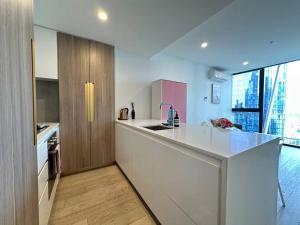 a kitchen with white counters and a large window at Avant CBD Cozy & Spacious 2BR Residences in Melbourne