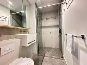een badkamer met een glazen douche en een wastafel bij Avant CBD Cozy & Spacious 2BR Residences in Melbourne