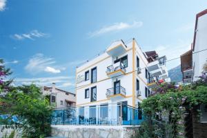 a large white building with balconies and trees at Enda Boutique Hotel Kalkan in Kalkan