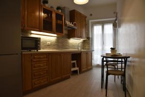 a kitchen with wooden cabinets and a table with a microwave at NathanaEle House Via Tuscolana in Rome