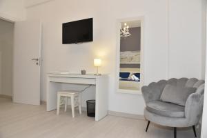 a living room with a chair and a desk with a television at NathanaEle House Via Tuscolana in Rome
