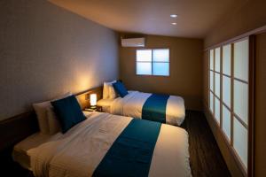 箱根Hotel Sengokuhara 533的有两张床和一扇窗户的卧室 更多37张照片