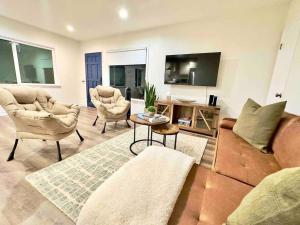 uma sala de estar com um sofá e duas cadeiras e uma televisão em LA Living near SoFI-LAX-Beach _House em Los Angeles