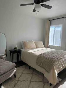 um quarto branco com uma cama e uma ventoinha de tecto em LA Living near SoFI-LAX-Beach _House em Los Angeles