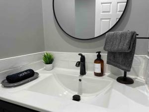 lavabo blanco con espejo encima en LA Living near SoFI-LAX-Beach _House, en Los Ángeles