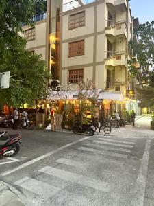 un bâtiment avec des motos garées sur le côté d'une rue dans l'établissement ila grand, à Hulhumalé
