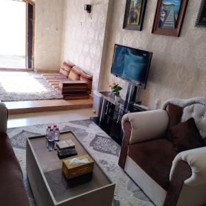 sala de estar con sofá y TV en العين الهيلي مصباح بيت 9, en Al Ain