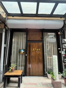 台南市にあるYou Ai Heya Homestayの木製の扉付きの建物の玄関