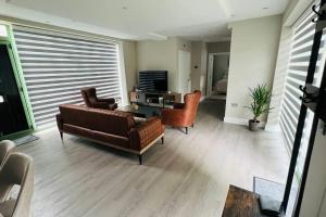 sala de estar con sofá de cuero y sillas en A house designed for you…, en Edmonton