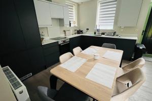 cocina con mesa de madera y armarios blancos en A house designed for you…, en Edmonton