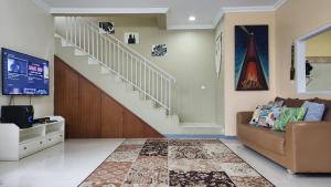 - un salon avec un escalier et un canapé dans l'établissement Alessandra Villa, à Lembang