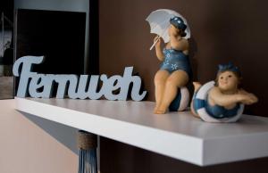 a figurine of a woman sitting on a shelf with an umbrella at Lotsenstieg 05 in Karlshagen