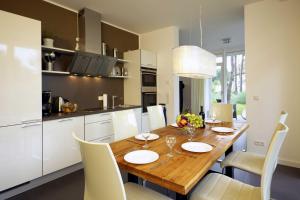 una cucina e una sala da pranzo con tavolo e sedie in legno di Lotsenstieg 05 a Ostseebad Karlshagen