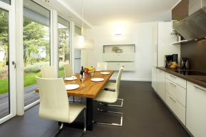 a kitchen with a wooden table and white chairs at Lotsenstieg 05 in Karlshagen