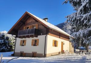 une maison avec un balcon dans la neige dans l'établissement Haus Waldschmied Exclusiv, à Stall