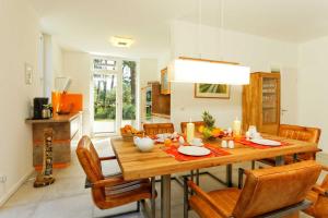 a kitchen and dining room with a wooden table and chairs at Lotsenstieg 13a in Ostseebad Karlshagen