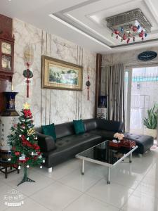 a living room with a black couch and a christmas tree at Lucky hotel in Ho Chi Minh City