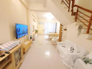 a large white living room with a large screen tv at 隨緣民宿 Suiian inn in Hengchun