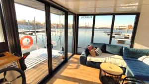 a living room with a couch and a view of a boat at Houseboat Water King apartament pływający dom na wodzie, 7 os in Wrocław