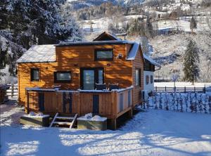 Cabaña de madera en la nieve con porche en Tiny House Waldschmied 1, 