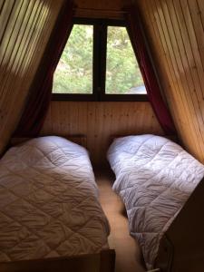two beds in a room with a window at Les Jonquilles in Les Angles