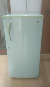 a white refrigerator freezer sitting on top of a floor at Mannat Rooms in Allahābād