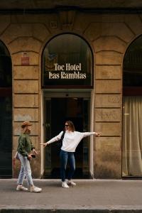 a woman standing in front of a building with her arms out at TOC Hotel Las Ramblas in Barcelona