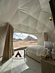 a bedroom with a tent with a view of the desert at Angelina Luxury Camp in Aqaba