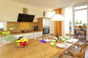 een keuken met een houten tafel en een eetkamer bij Lotsenstieg 2 Kajuete 07 in Ostseebad Karlshagen