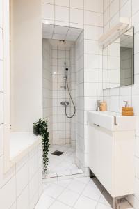 baño blanco con ducha y lavamanos en Dinbnb Apartments I 500m to Bryggen, en Bergen