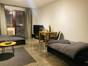 Zimmer mit 2 Betten, einem Tisch und einem Schreibtisch in der Unterkunft Schönes Wohnen in Groß-Buchholz - Zentral+Modern in Hannover