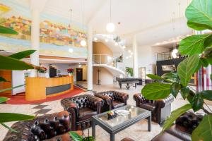 a lobby with leather couches and a piano at Hotel Landskron in Bruck an der Mur