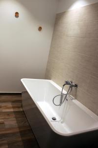 a white bath tub in a bathroom with tiles at Le clos Champlieu in Orrouy